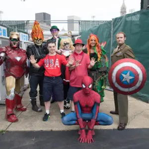 Superheroes pose with group at disability parade