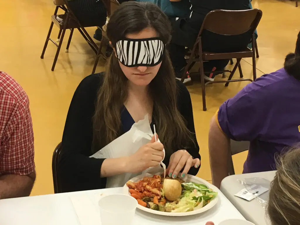 Lunch in the dark attendees trying their meal while blindfolded