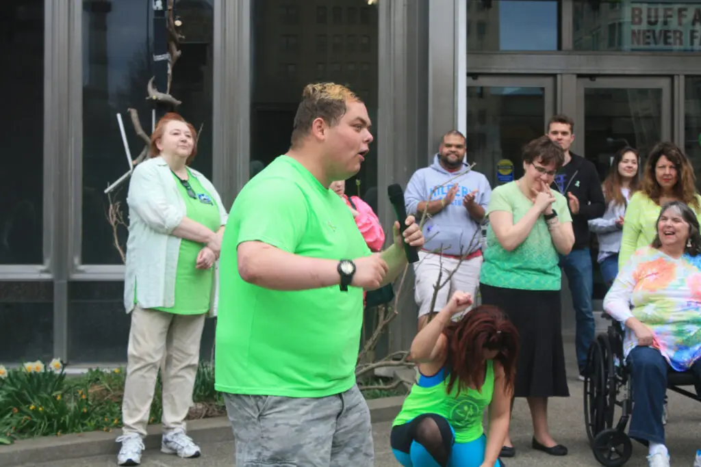 MHPC flash mob attendee speaking on microphone outside of the Buffalo Public Library