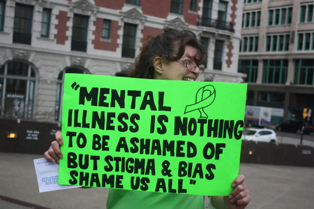 MHPC flash mob sign that reads, "Mental illness is nothing to be ashamed of but stigma and bias shame us all."